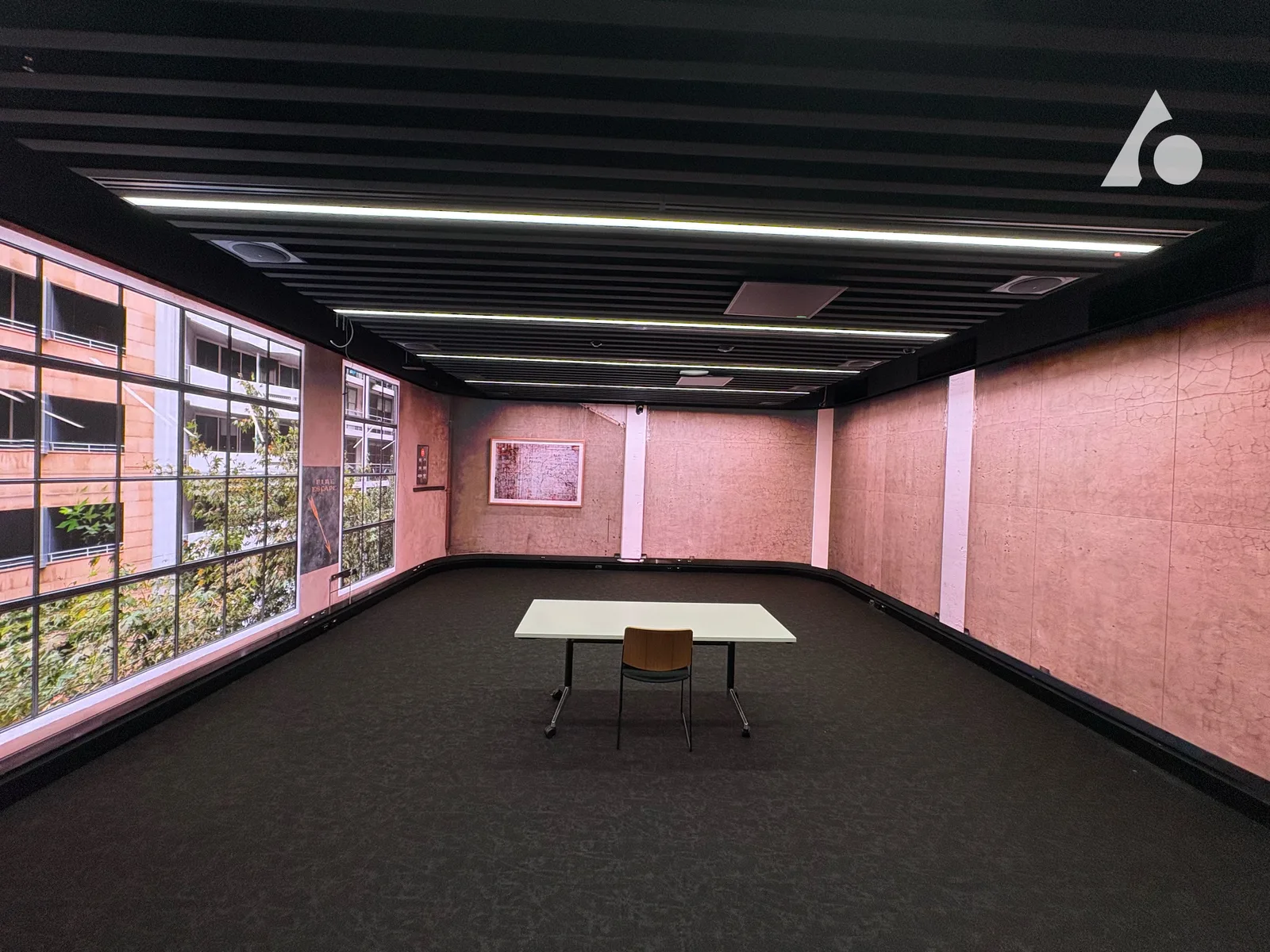 Aurora wrap-around LED immersion room with floor-to-ceiling panels rendering a corporate office window scene on one wall and a textured pink stone wall on the other