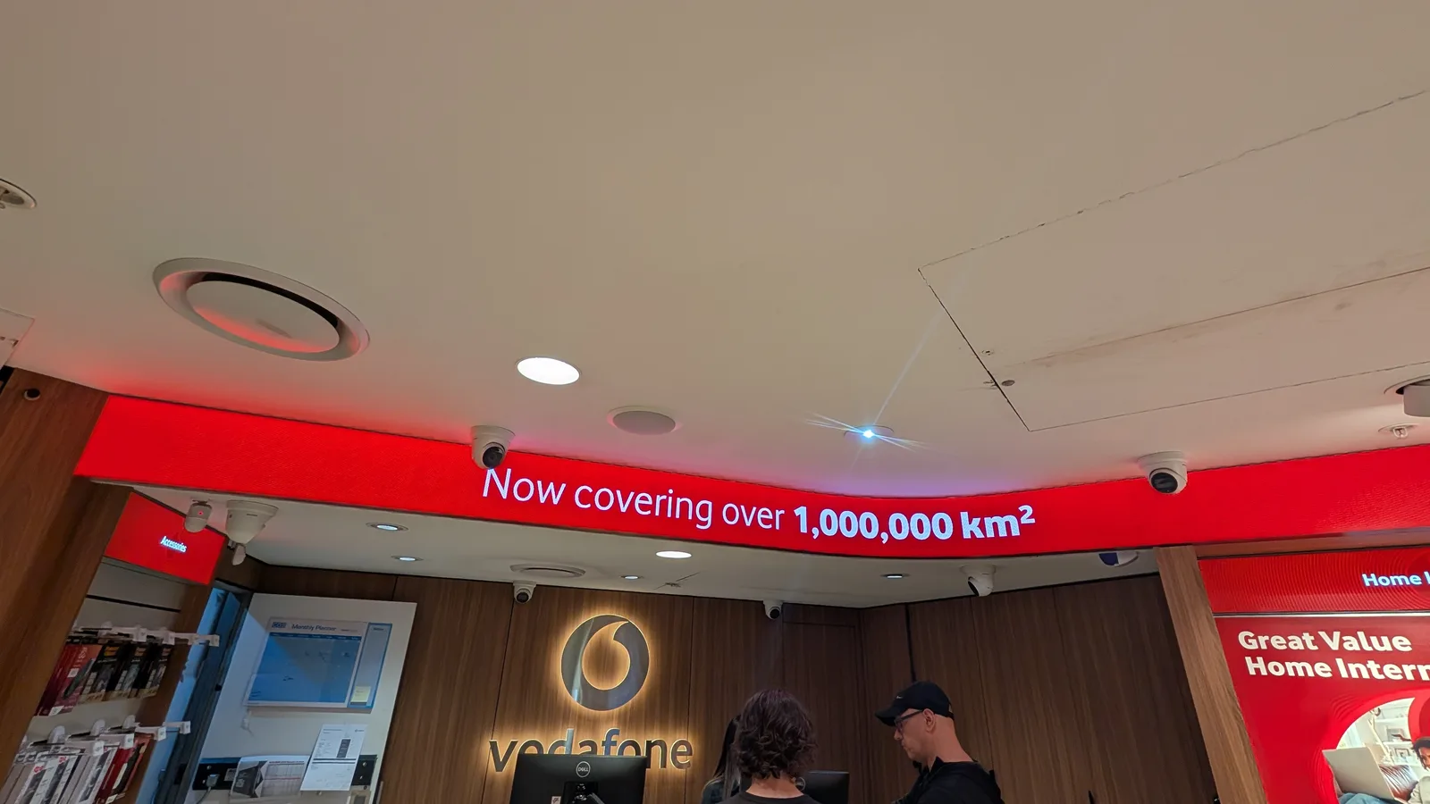 Aurora curved LED ribbon display in a Vodafone retail store reading "Now covering over 1,000,000 km²"
