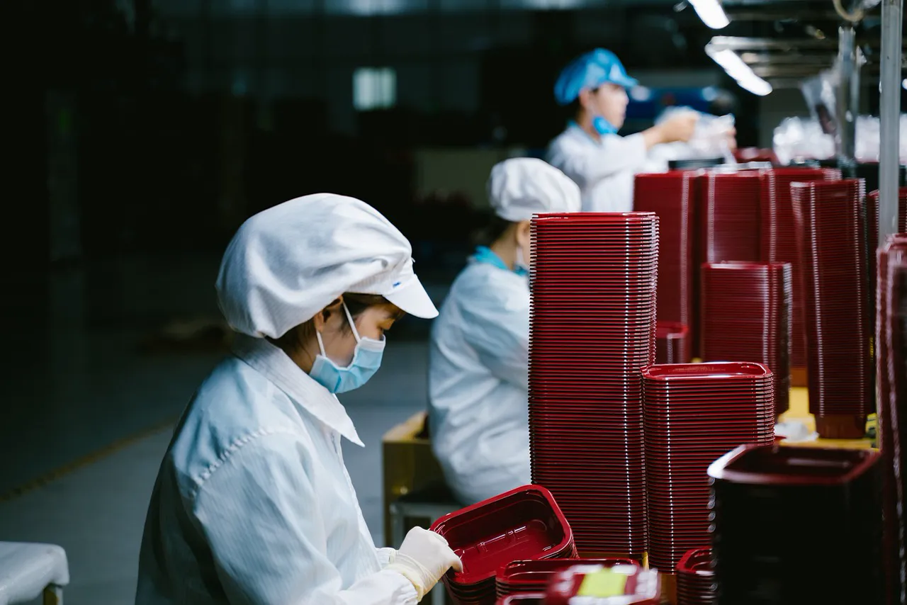 Technicians assembling electronic boards in a clean, well-lit manufacturing facility
