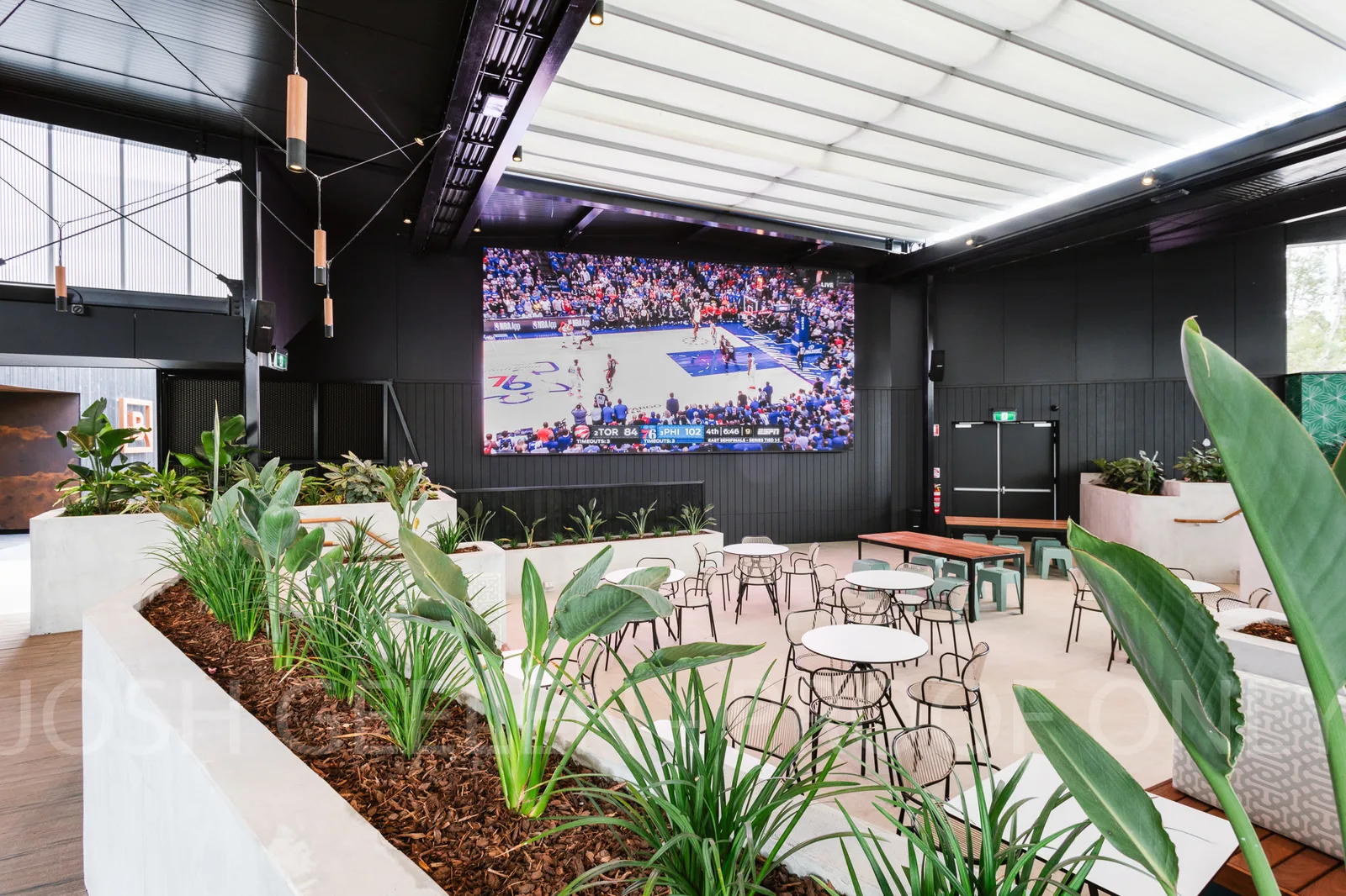 Aurora GSR fixed-install indoor LED screen at the Bridgeway Hotel sports lounge showing live NBA basketball coverage above café-style seating